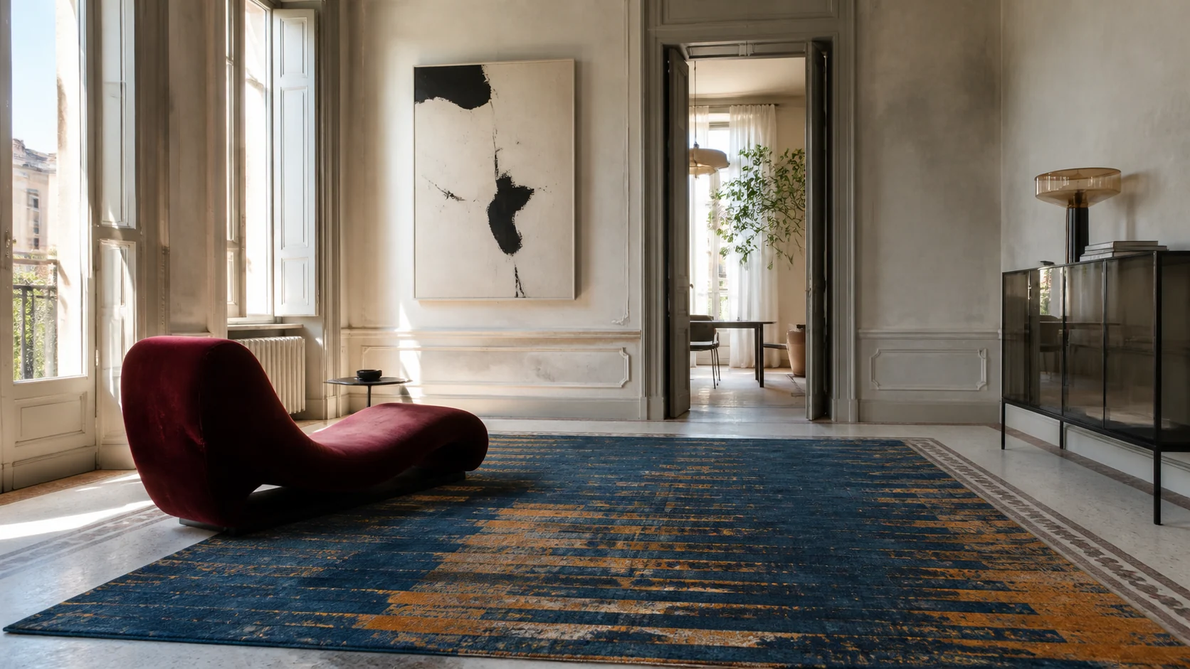 Tapis bleu et ocre dans un appartement lumineux avec une assise bordeaux